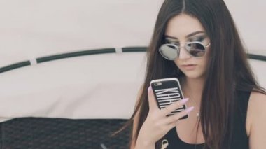 Telefon açık kullanarak güneş gözlüklü kız