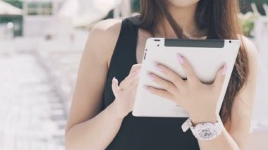İskelede duran, tablet kullanma ve gülümseyen akıllı kız. Yavaş yavaş
