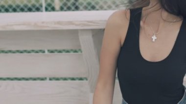 Bankta oturan güneş gözlüklü kız dokunmadan ve saçlarını dönüm. Yavaş yavaş