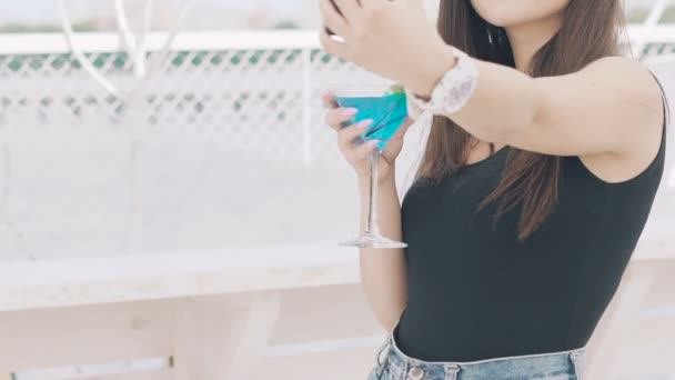 Menina tomando selfie com cálice de coquetel azul na praia — Vídeo de Stock