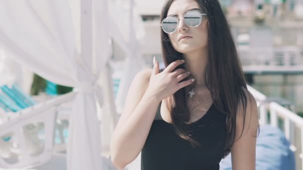 La chica con gafas de sol tocando el pelo y mirando a un lado. Movimiento lento — Vídeo de stock