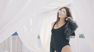 Seksi kız siyah ve beyaz çardak denize yakın poz güneş gözlüğü. 4k