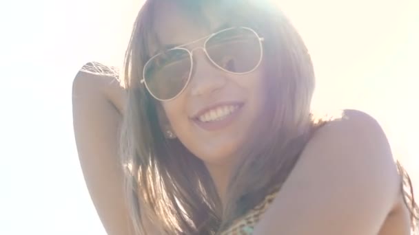 Πορτρέτο του όμορφη θηλυκά πρόσωπο χαμογελά σε ηλιόλουστο ουρανό φόντο. Σιγά-σιγά — Αρχείο Βίντεο