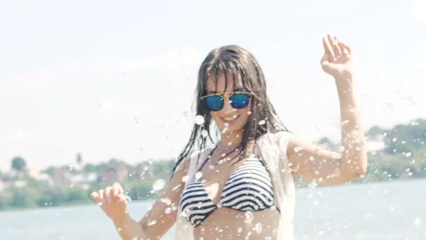 Mujer disfrutando y saltando con olas y gotas de agua en el río. Despacio. — Vídeos de Stock