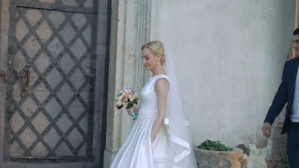 Жених следует за невестой возле замка. Медленно. — стоковое видео