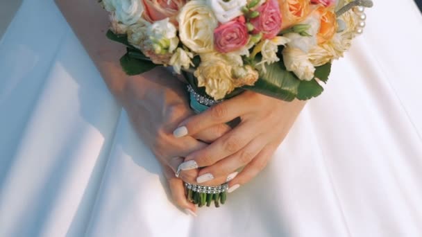 Beau bouquet de mariée entre les mains d'une jeune mariée vêtue de robe. Doucement. — Video