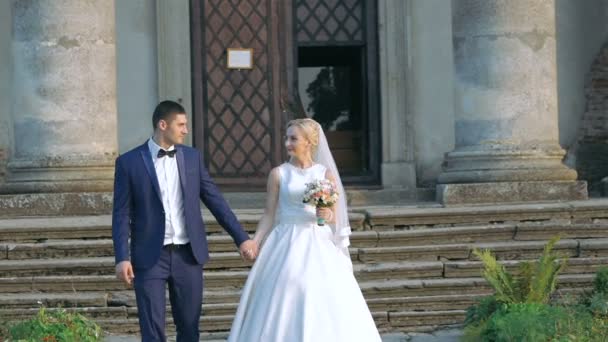 Pareja de bodas caminando cerca del viejo castillo. Despacio. — Vídeo de stock