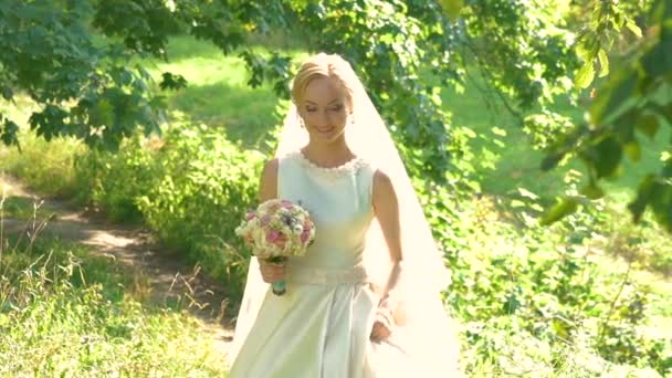 Noiva com o buquê de casamento andando no parque. Devagar. — Vídeo de Stock