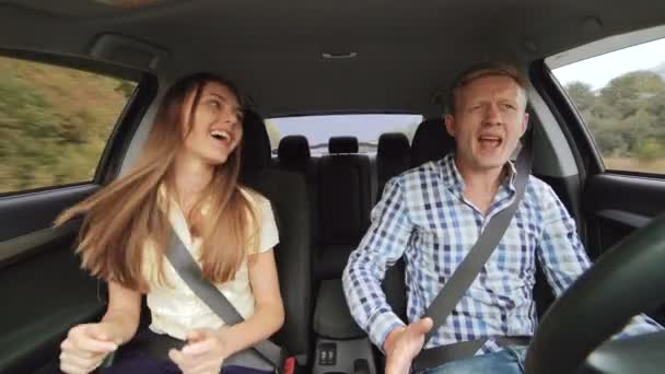 O menino e a menina em estilo de negócios dançando no carro em 4K — Vídeo de Stock