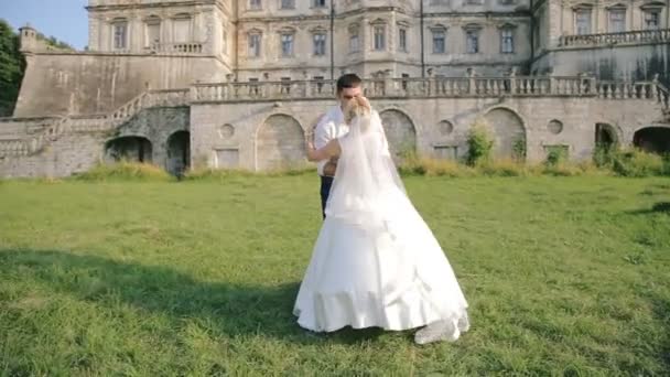 Молодая супружеская пара целуется возле замка — стоковое видео