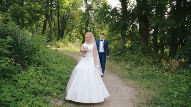 Hochzeitspaar spaziert im alten Park in der Nähe von Ruinen