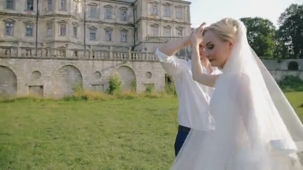 Casamento casal apaixonado rodopiando perto do castelo — Vídeo de Stock