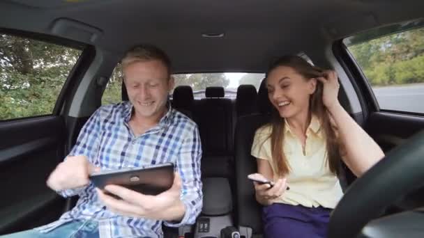 Fille dans la voiture, en utilisant le téléphone, garçon assis dans la voiture avec tablette, discuter 4K — Video