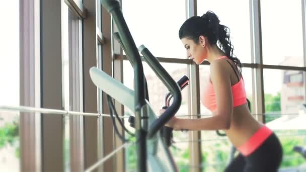 La femme faisant de l'exercice avec un vélo d'appartement dans une salle de gym — Video