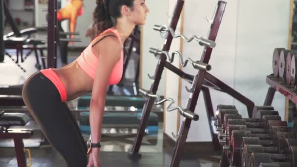 Perfil da menina usando barra para exercícios no ginásio. Devagar. — Vídeo de Stock