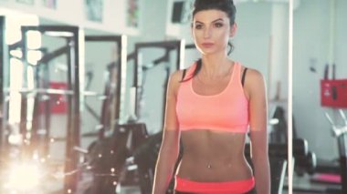 Genç kadının spor salonunda ayna önünde çömelme yapması