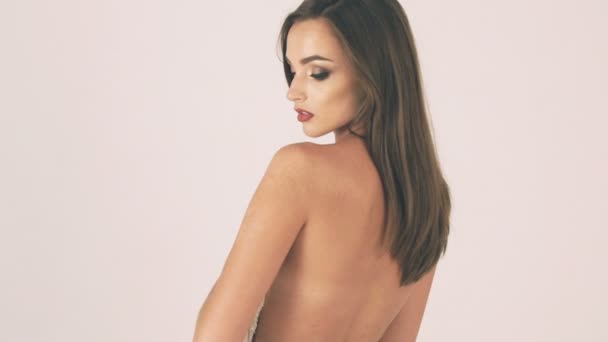 Beautiful girl on a white background with a bare back — Stock Video