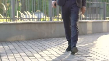 Kendine güvenen adam sokakta telefon ile siyah gider giymiş. Yavaş yavaş