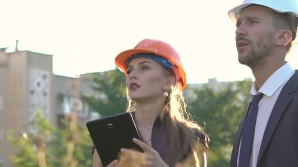 Arquiteto e capataz verificando projeto de construção em tablet e sorrindo — Vídeo de Stock