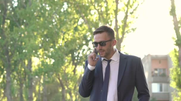 Homem irritado em preto falando no telefone, despir óculos de sol e está nervoso — Vídeo de Stock