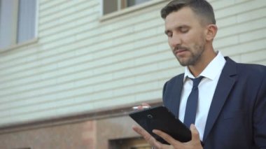 Tablet ve Sigara İçilmeyen açık kullanarak ciddi iş adamı. 4k