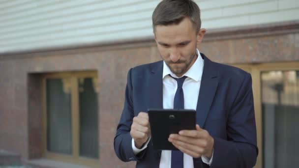 Empresário irritado enquanto trabalhava com tablet ao ar livre. 4K — Vídeo de Stock