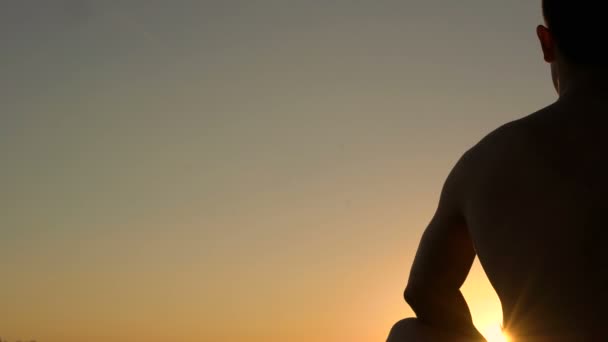 Meditación del hombre cerca del mar sobre el fondo del cielo. 4K — Vídeo de stock