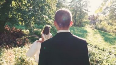 Yakışıklı damat gelin parkta gelir. Yavaş yavaş