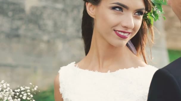 Intelligens menyasszony mosolyogva a vőlegény szél nap szabadtéri. Lassan — Stock videók