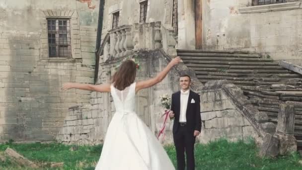 Έξυπνη νύφη εκτελεί στο γαμπρό στέκεται με μπουκέτο. Σιγά-σιγά — Αρχείο Βίντεο