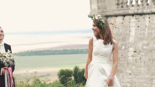 Beau marié vient à charmante mariée avec bouquet. Doucement. — Video