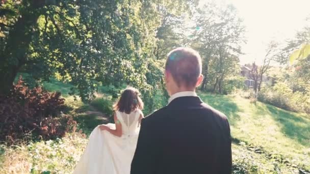 Pohledný ženich přichází nevěsta s úsměvem v parku. Pomalu — Stock video