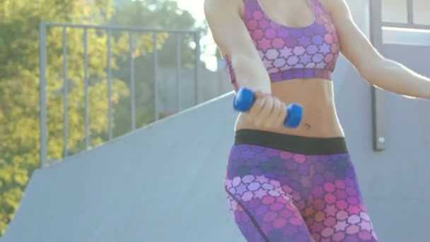 Zwei sexy Mädchen, die draußen Straßenübungen mit Gewichten machen. langsam — Stockvideo
