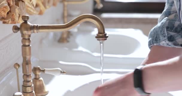 Close view of male hands washing with soap under flowing faucet of washstand — Stock Video
