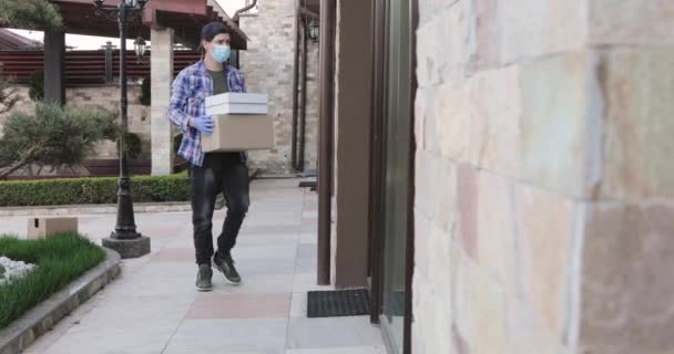 Man contactless delivers parcel at home doorstep, knocks on doors and come away — Stock Video