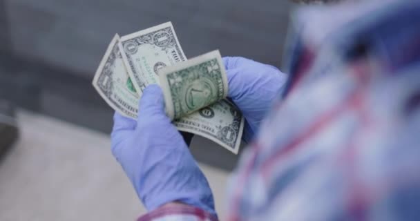 Le mani maschili in guanti protettivi tengono due dollari e li stringono nelle mani — Video Stock