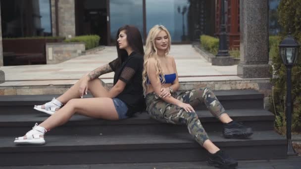 Sexy brunette and blonde with long hair posing on stairs at house — Stock Video