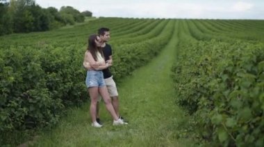 Birbirini seven mutlu çift üzümlü fidanlığı izliyor.