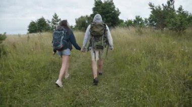 Aşık mutlu çift doğada yürüyor ve kıvranıyor. 4K