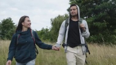 Mutlu çift doğada yürüyor kucaklaşıyor ve öpüşüyor.