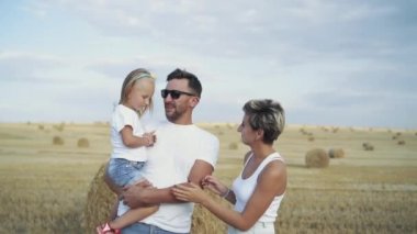Mutlu bir ailenin portresi, ellerinde kızıyla konuşuyor ve gülümsüyor.