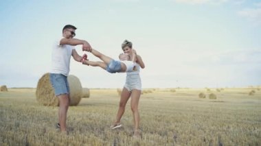 Mutlu ebeveynler çocuğu sallar ve parlak ufuk çizgisinde onu öperler.