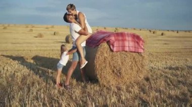 Hoş bir adam geniş bir arazide küçük kızına sarılıyor.