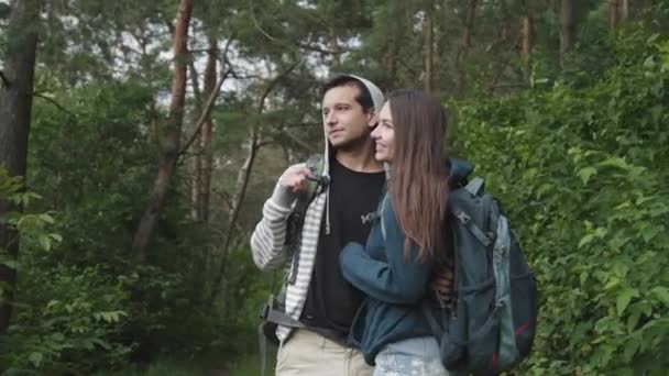 Ormanda yürüyüp eğlenen ve uzaklara bakan sevimli bir çift. — Stok video