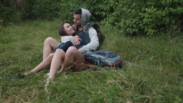 Glückliches verliebtes Paar entspannt sich in Umarmungen im Gras und lächelt — Stockvideo