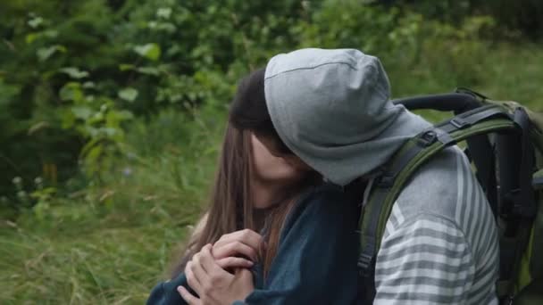 Happy couple in love relaxing in embraces on grass and kissing — Stock Video