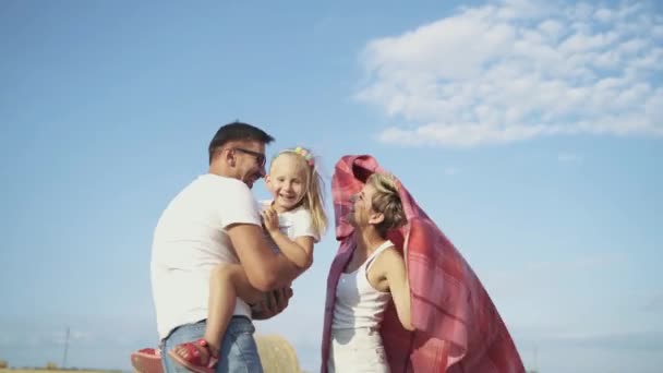 Padres felices divirtiéndose y jugando con su hija en un hermoso campo — Vídeos de Stock