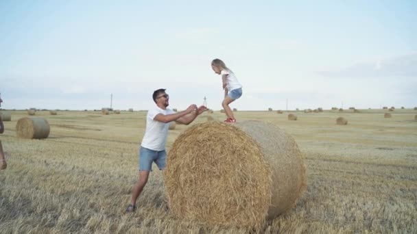 Kleines Mädchen springt Vater in die Hände und Mutter kommt und umarmt — Stockvideo