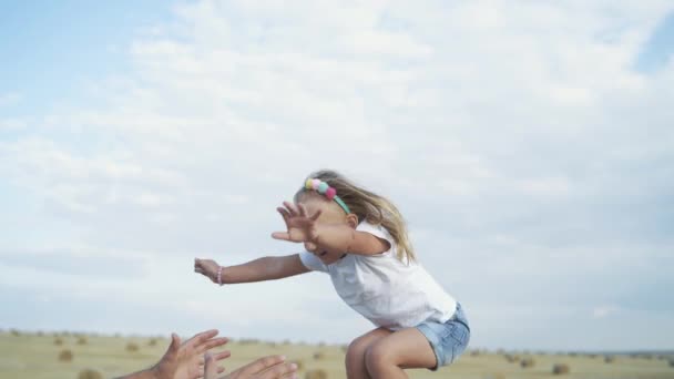 Ritratto di bambina salta nelle mani dei padri, la madre viene e abbraccia — Video Stock