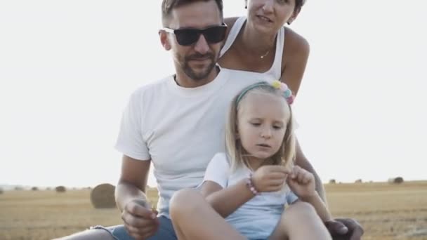 Ritratto di famiglia felice braccia aperte alla macchina fotografica sul fieno in campo — Video Stock